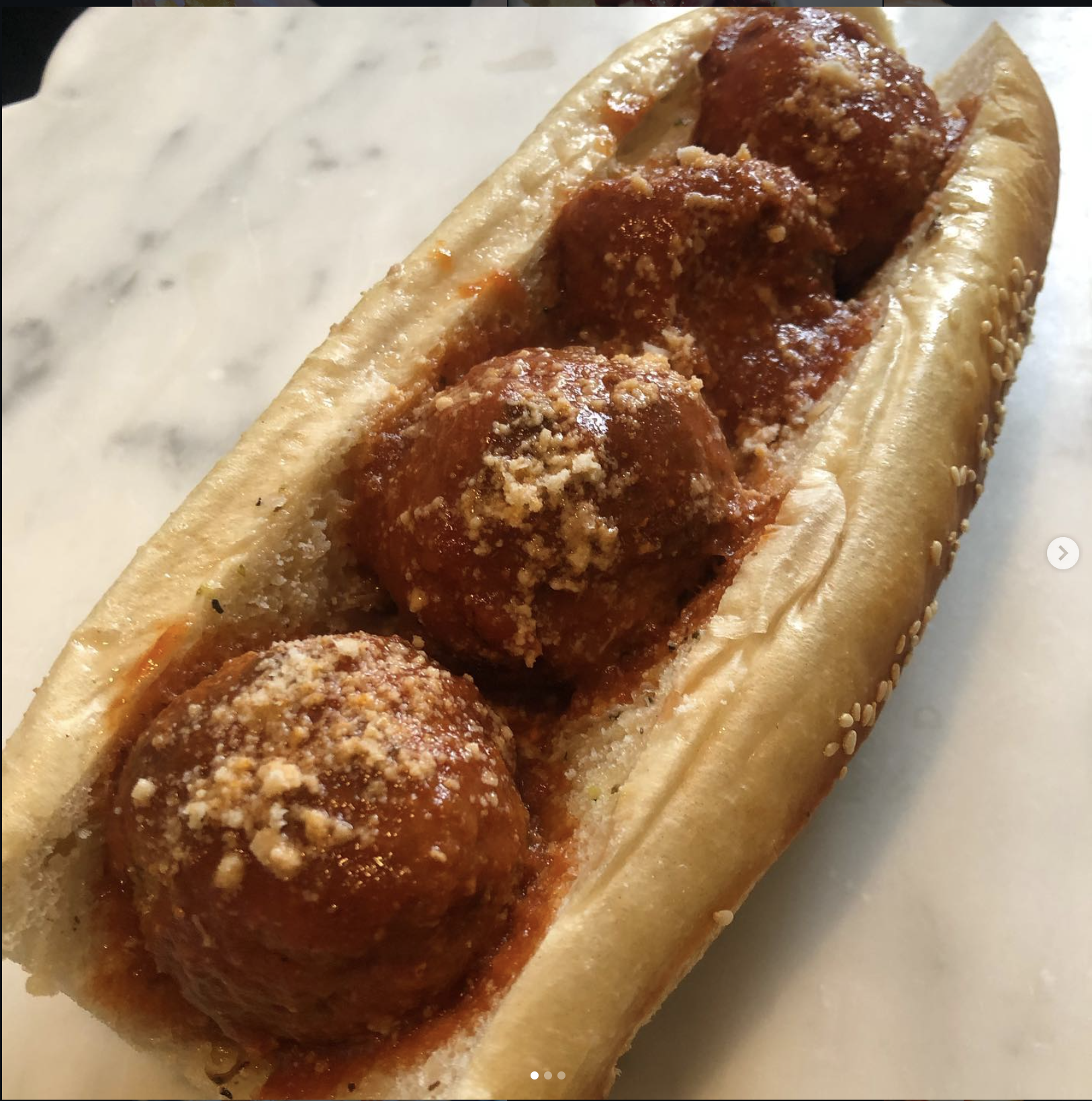 Santini's signature meatball sandwich with gravy and grated cheese